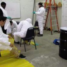 People suiting up for hazardous waste training.