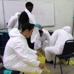 People suiting up for hazardous waste training.