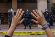 A demonstrator holds their hands up while they kneel in front of the police at the Anaheim City Hall on June 1, 2020 in Anaheim, California, during a peaceful protest over the death of George Floyd. (Apu Gomes/AFP/Getty Images)
