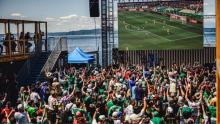 a crowd watches a World Cup match on a large screen at the Seattle Waterfront