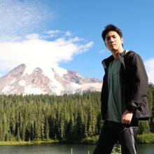 image of Yuan Hsiao standing near a lake with trees and Mt Rainier in the background
