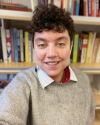 A headshot of Professor Rosalind Kichler standing in front of a bookshelf 