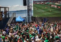 a crowd watches a World Cup match on a large screen at the Seattle Waterfront